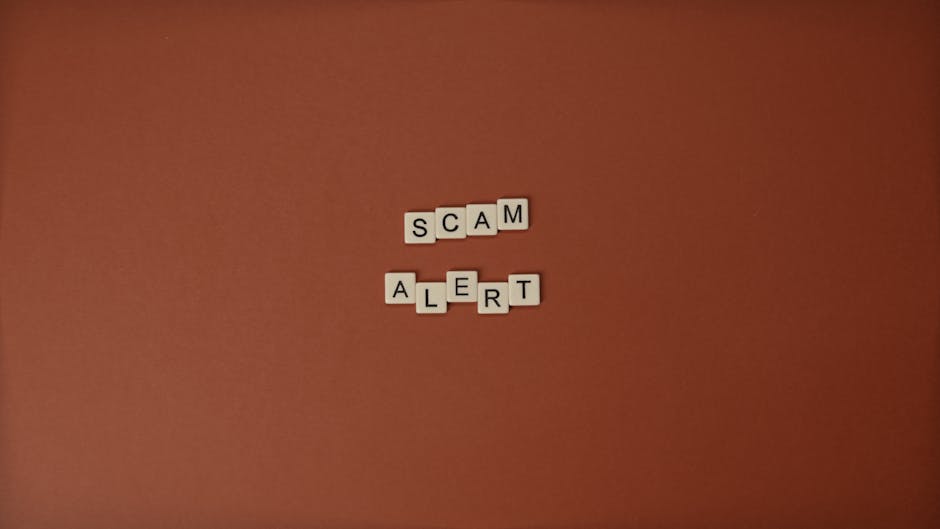 Scrabble tiles spelling Scam Alert on a brown surface indicating caution.