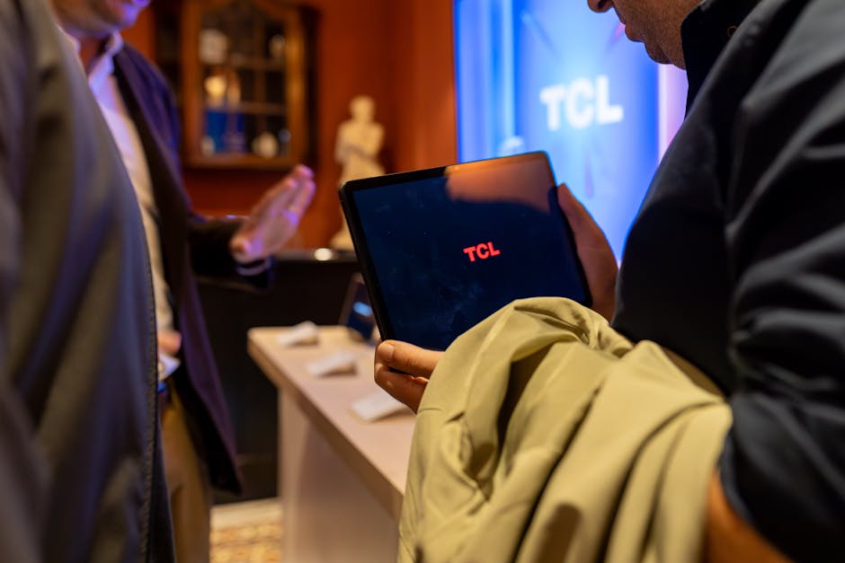 Two men discussing business insights using a TCL tablet in an elegant indoor setting.